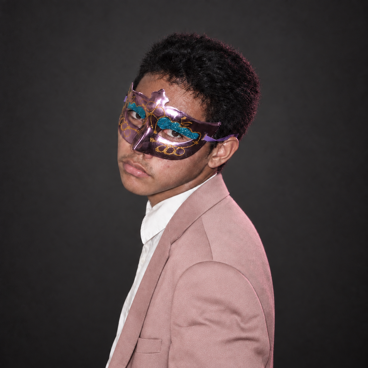 Adrian Seth M. Tabotabo in pink blazer and masquerade mask